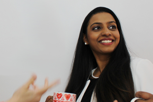 Alisa Pereira, a leading Immigration lawyer at Mulgrave Law, smiling while holding a mug decorated with hearts.